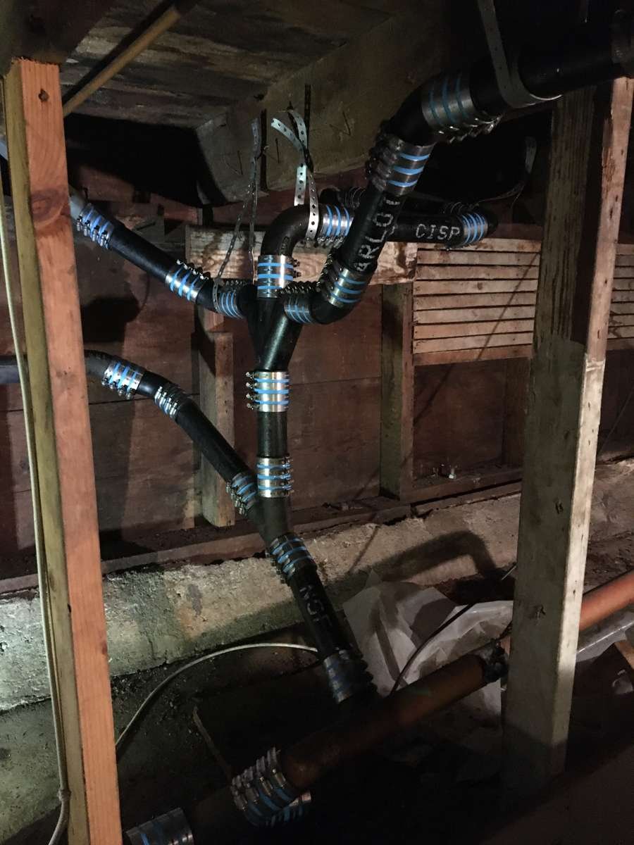 Subfloor drain repipe with shielded no-hub couplings between joists
