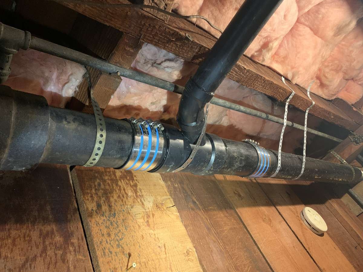 ABS drain line replacement with shielded couplings in an attic crawl space