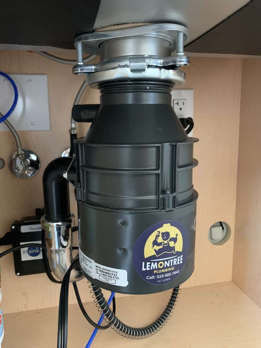 New garbage disposal installed under a kitchen sink