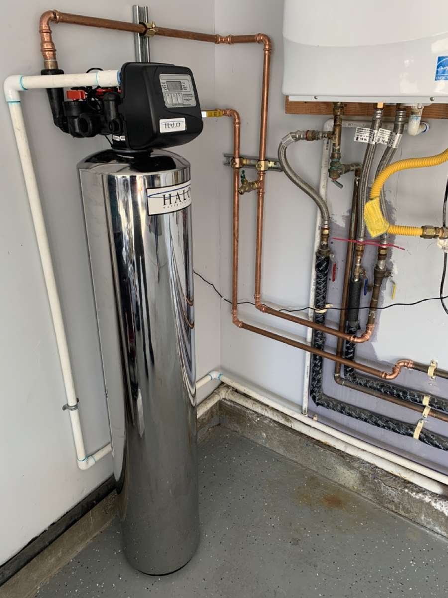 Whole-house water filtration system installed in a garage