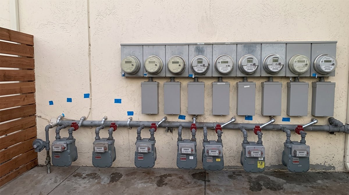 Row of multi-unit gas meters with new piping and shut-off valves